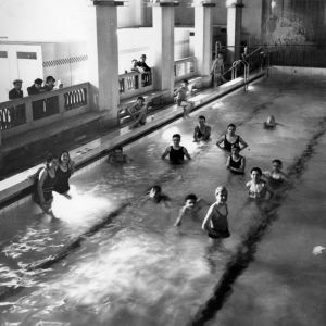 Palais du travail, piscine : bassin avec baigneurs et spectateurs. Photographie. Archives municipales de Villeurbanne / Le Rize, 4 Fi 436.