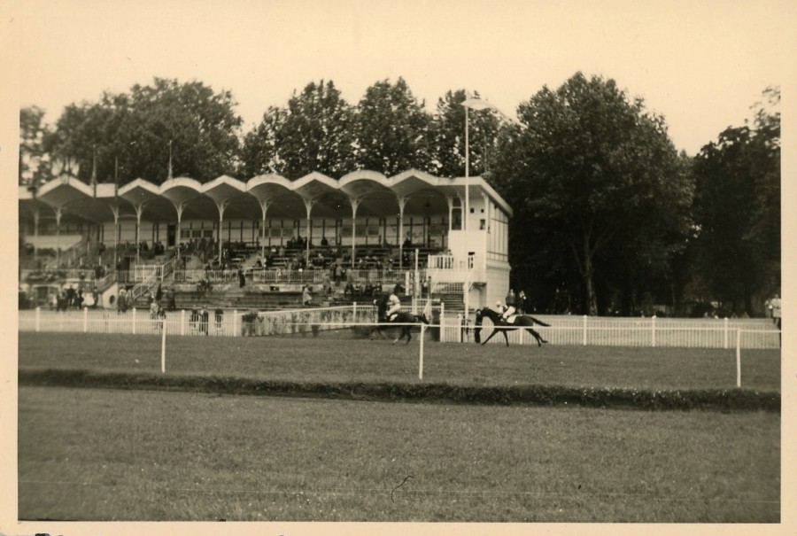 courses de mai 1954 : passage de deux cavaliers devant la tribune (19Fi516)