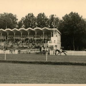 courses de mai 1954 : passage de deux cavaliers devant la tribune (19Fi516)