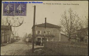 La route de Genas, les Sept-chemins, vue en perspective de la voie, au-delà de Villeurbanne. Carte postale, tampon de la poste du 19 septembre 1927, éd. Roux. [cote 2Fi231]